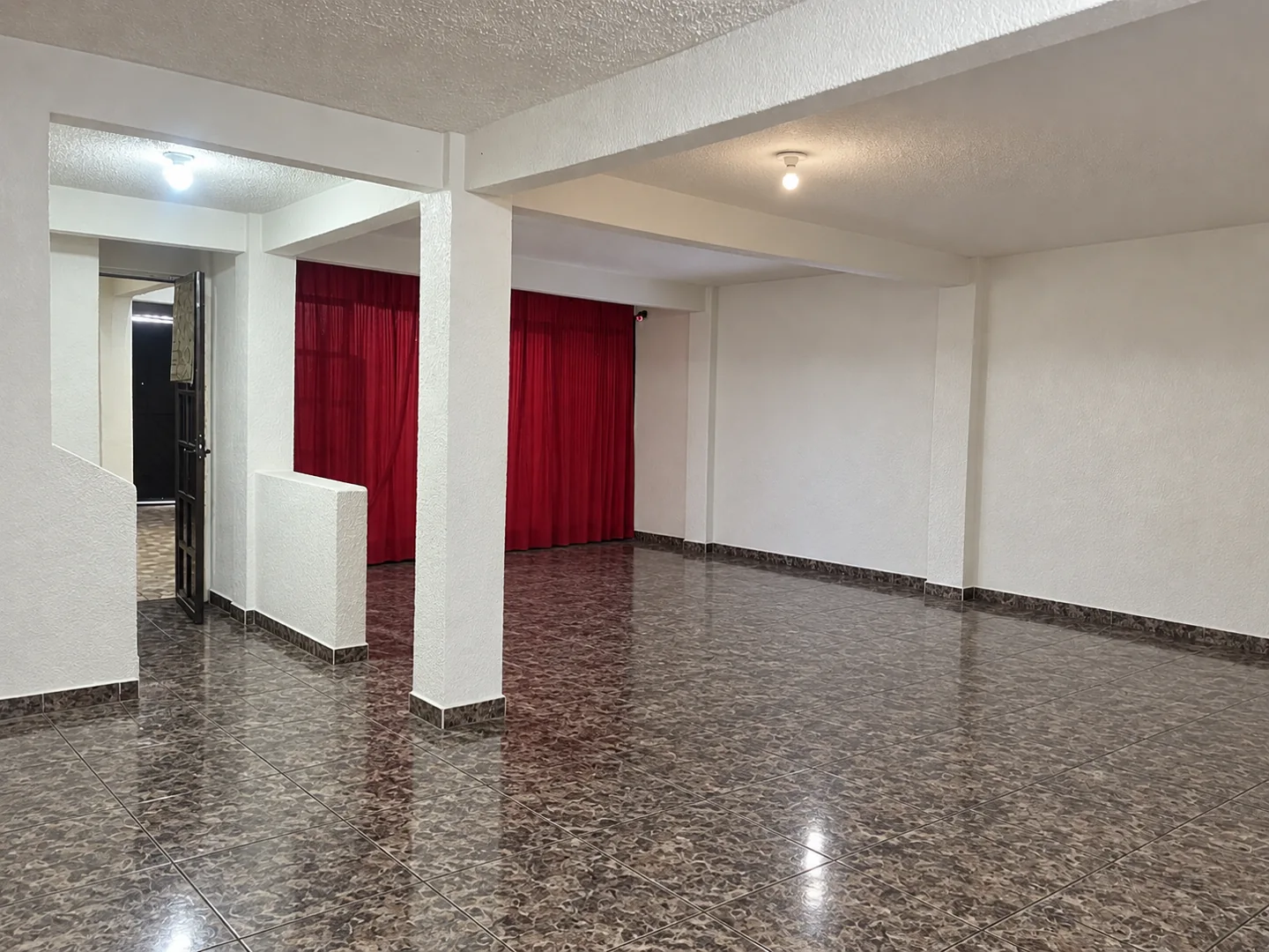 Sala con cortinas rojas de Compás 38